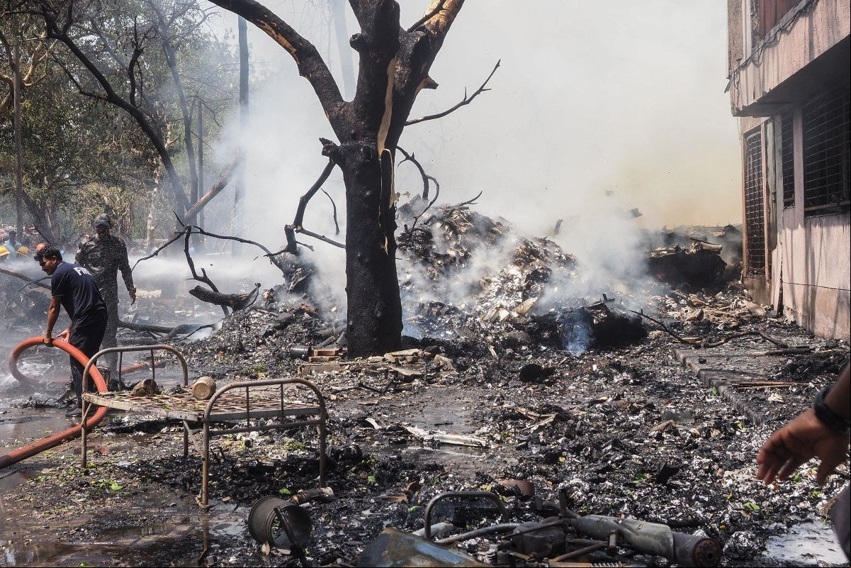 Bombeiros trabalham no local onde o voo 171 da Air India caiu em uma área residencial perto do aeroporto de Ahmedabad