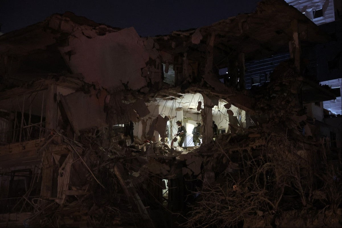 Tropas israelenses verificam um prédio atingido por um míssil disparado do Irã, em Ramat Gan, perto de Tel Aviv