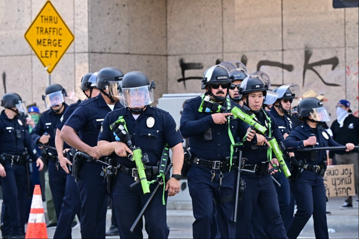 Policiais entram em confronto com manifestantes do lado de fora do Centro de Detenção Metropolitano (MDC), durante um protesto após operações federais de imigração, no centro de Los Angeles